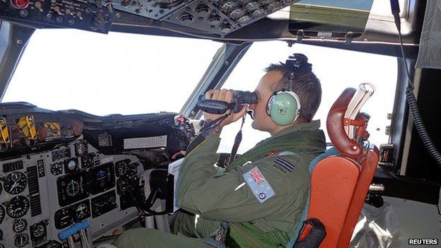 A Royal Australian Air Force pilot of an AP-3C Orion maritime patrol aircraft scans the surface of the sea near the west of Peninsula Malaysia in this handout picture by the Royal Australian Air Force on 17 March 2014