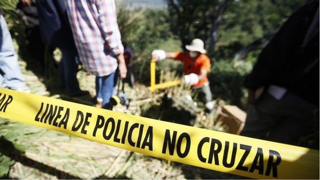 Police tape is seen around a cordoned off area where forensic technicians work during an exhumation at a hidden mass grave discovered in Lourdes, El Salvador