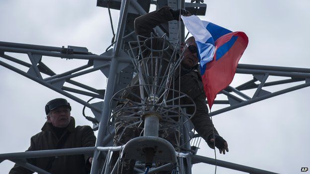 Pro-Russian forces hang up a Russian flag after seizing the Ukrainian corvette Khmelnitsky in Sevastopol, Crimea (March 20, 2014)
