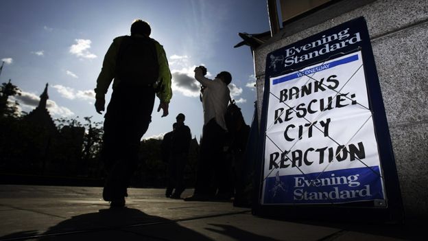 2008: man walks past Evening Standard billboard: "Banks rescue: City reaction"