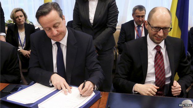 Britain's Prime Minister David Cameron sits next to Ukraine's Prime Minister Arseniy Yatsenyuk (R) during a signing ceremony at a European Union leaders summit in Brussels (March 21, 2014)