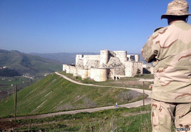 A Syrian soldier looks towards the Krak des Chevaliers castle near the Lebanese border, 20 March