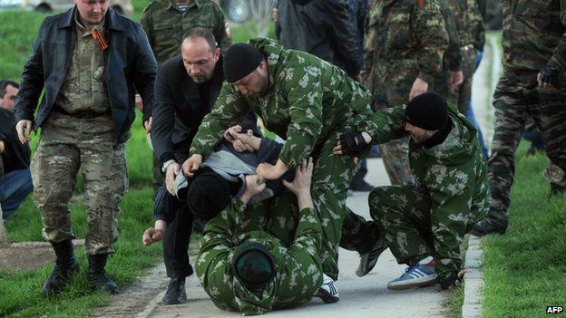 Pro-Russian men beat an unknown man during the takeover of the Belbek airbase on Saturday