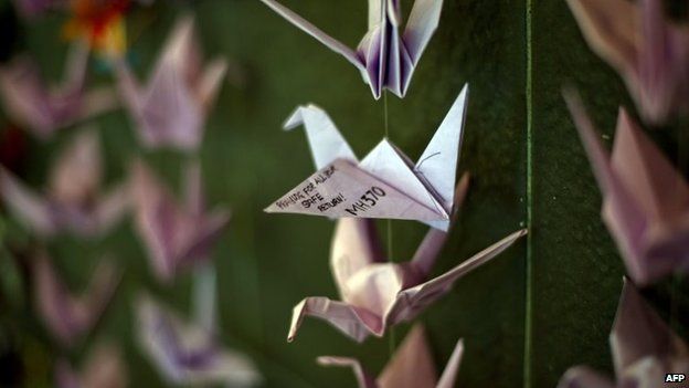 Origami cranes containing prayers and messages for those on board flight MH370 hanging from a wall at a shopping centre in Bangsar, Malaysia (23 March 2014)