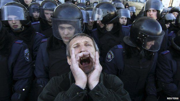 A pro-Russian protester shouts slogans in front of Ukrainian riot police guarding the regional administration building during a rally in central Donetsk on 22 March 2014
