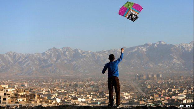 Afghan boy flies a kite on a hillside overlooking Kabul (17 February)