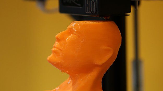 A 3-D printer creates a bust of actor Bruce Willis.