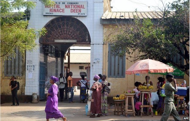 People walk in front of the Ignace Deen hospital in Conakry on 27 March