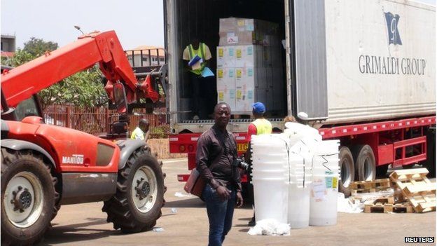 Workers from Doctors Without Borders unload emergency medical supplies from the back of a lorry, to deal with the country's Ebola outbreak