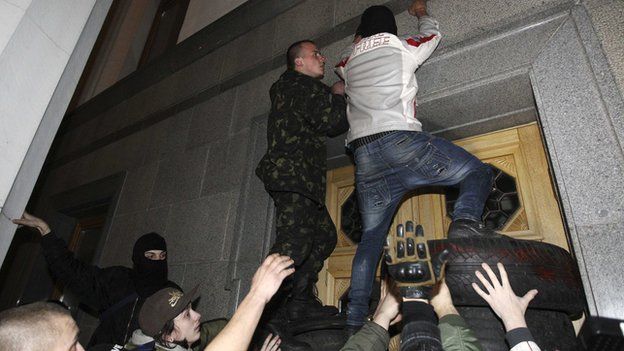 Men climb onto the parliament building as activists of the Right Sector movement and their supporters gather to demand the immediate resignation of Internal Affairs Minister Arsen Avakov, in Kiev March 27, 2014.