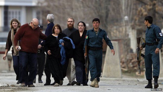 Policemen evacuate foreigners from the site of the attack in Kabul