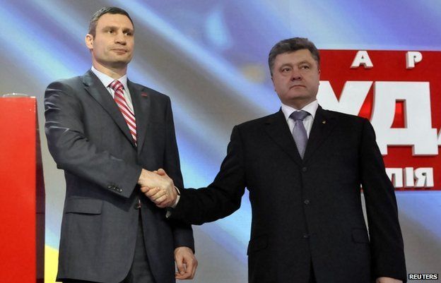 Ukrainian politicians Vitaly Klitschko (L) and Petro Poroshenko shake hands during a party meeting
