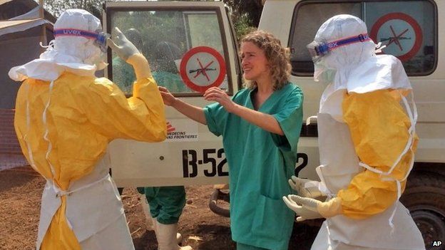 In this photo provide by MSF, Medecins Sans Frontieres (Doctors without Borders), taken on Friday, March 28, 2014, healthcare workers from the organisation, react, as they prepare isolation and treatment areas for their Ebola, hemorrhagic fever operations, in Gueckedou, Guinea.