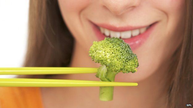woman eating broccoli