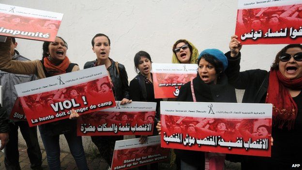 Tunisian activists hold placards during a demonstration against violence against women outside a court in Tunis hearing the trial of two Tunisian policemen accuse of raping a young woman. 31 March 2014