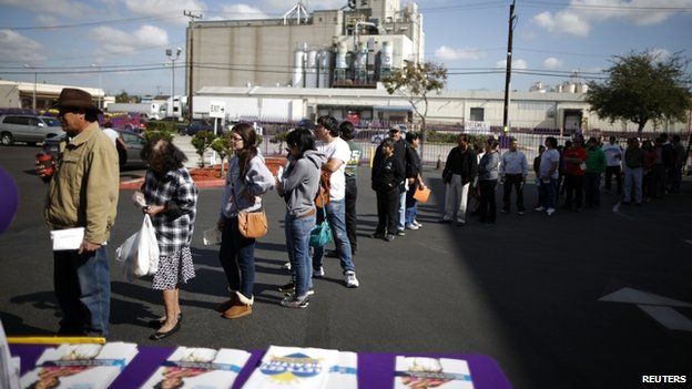 People wait in line to sign up for health insurance at an enrolment event in Commerce, California, on 31 March 2014.