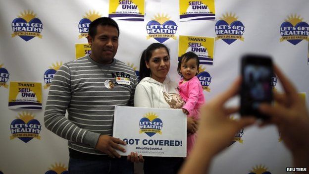 Enrique Gonzalez, 22, Janet Regalado, 21, and their nine-month-old daughter pose for a photo after signing up for health insurance in California on 31 March 2014.