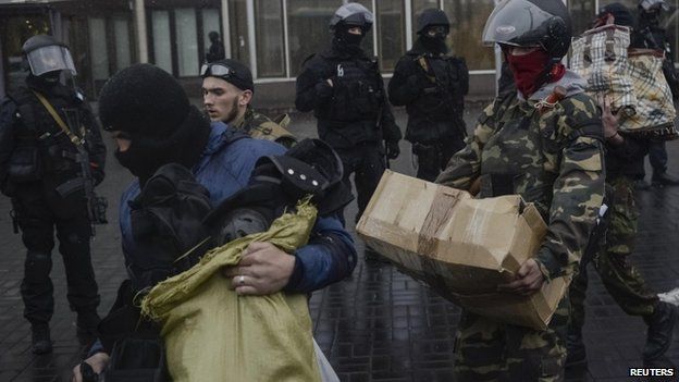 Members of the Ukrainian radical group Right Sector leave their headquarters in Dnipro Hotel in Kiev as police special forces stand guard. Photo: 1 April 2014