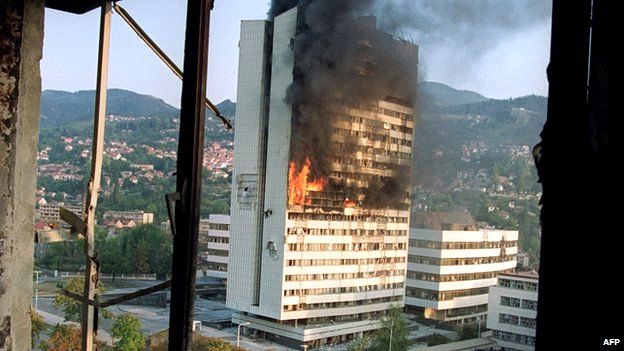 Parliament building aflame in Sarajevo after being struck by a shell