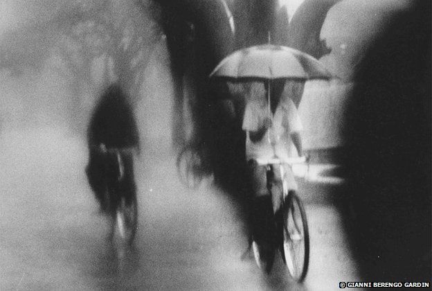 Despite the torrential rains, cyclists continue to move indifferent to their discomfort. 1977-79