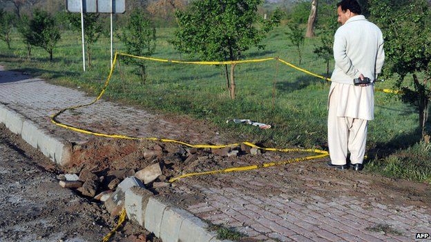 A Pakistani plainclothes security official inspects the site of a bomb explosion in Islamabad on 3 April 2014.