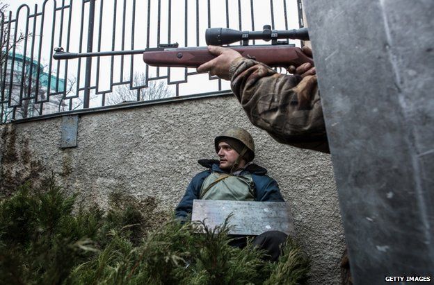 An opposition activist aims a rifle in Kiev, 20 April