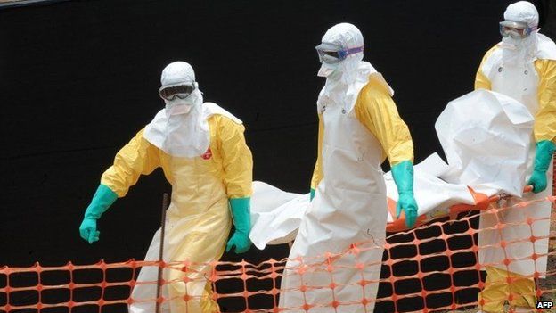 Staff of the "Doctors without Borders" ("Medecins Sans Frontieres") medical aid organisation carry the body of a person killed by viral haemorrhagic fever, at a centre for victims of the Ebola virus in Guekedou, on 1 April 2014