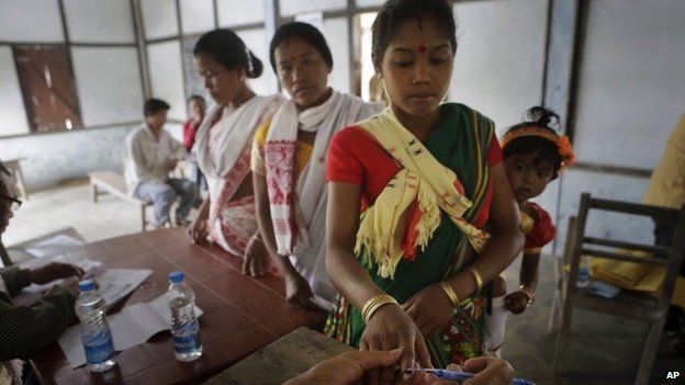 An election officer applies indelible ink mark on the finger of a Mishing tribal woman voter during the first phase of elections at Misamora Sapori, an island in the River Brahmaputra in the northeastern Assam state, India, Monday, April 7, 2014.