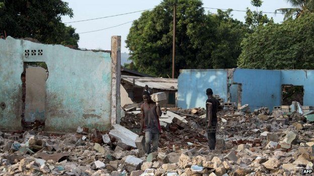 Two Christian men work on 3 April 2014 in the wreckage left after an old mosque and Muslim-owned shops were destroyed by anti-balaka militias in Bangui, CAR