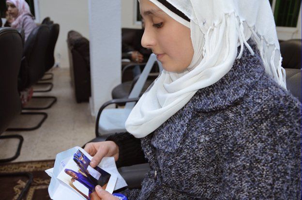 A Syrian girl holds a photo of a Somali refugee who has sent her a letter