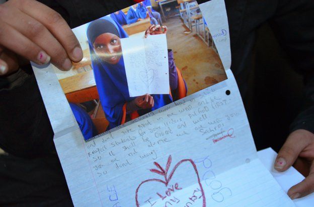 A photo of a Somali girl is held up next to her letter
