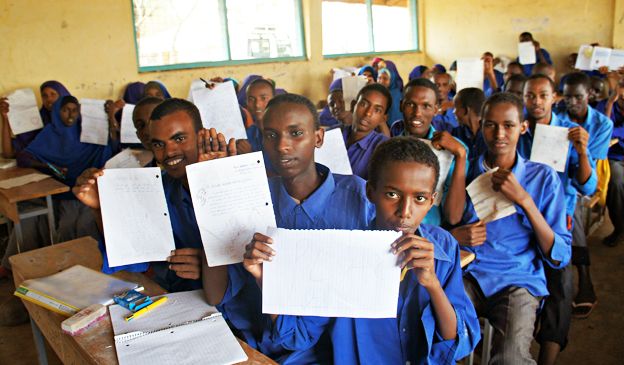 Young Somali refugees hold up the letters they've written to Syrian refugees