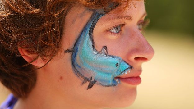 Protester with shark painted on face