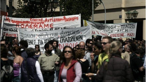 Protesters carry banners as they march towards Parliament during a labour strike on 09/04/14 in Athens, Greece.
