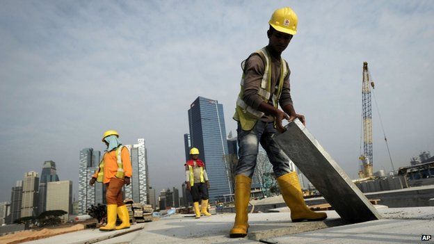 Migrant workers from India construct a road leading to the Financial District in Singapore, 4 February 2014