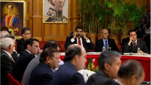 Venezuelan President Nicolas Maduro, top centre, looks toward leaders of the opposition at the start of a meeting at Miraflores presidential palace in Caracas, Venezuela, 10 April