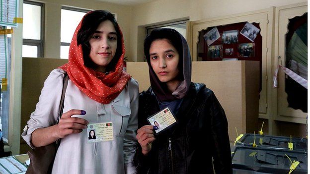 Two young female voters show of their voting ID cards in a Kabul polling station