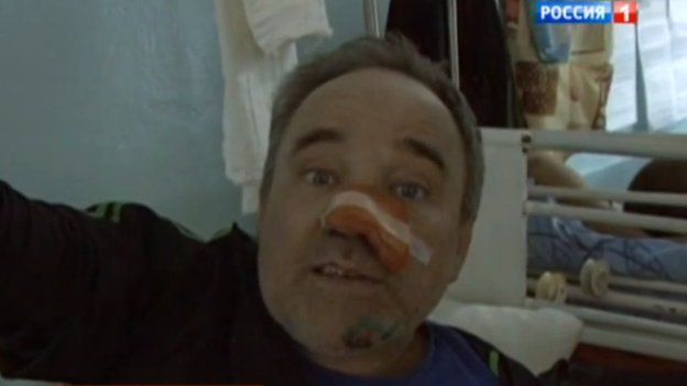 Screenshot of a news bulletin on Rossiya 1 with an activist in a hospital bed