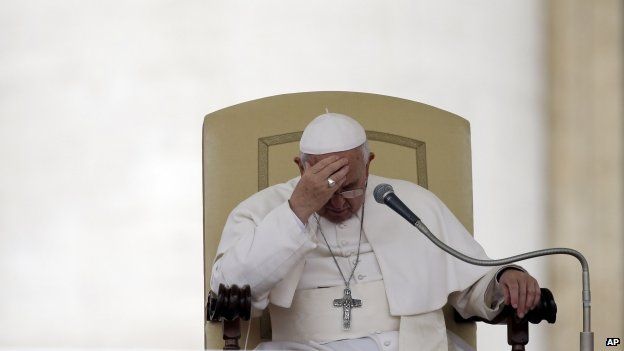 File photo: Pope Francis touches his forehead after delivering his message during the general audience in St. Peter's Square, at the Vatican, 9 April 2014