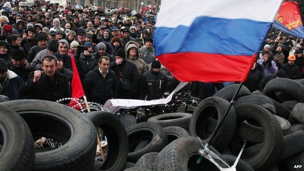 Pro-Russian activists rally at a barricade outside the regional state administration in the eastern Ukrainian city of Donetsk, 11 April 2014