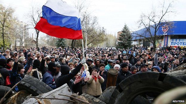 Protesters wave the Russian flag in front of police station in Slaviansk 12/04/2014