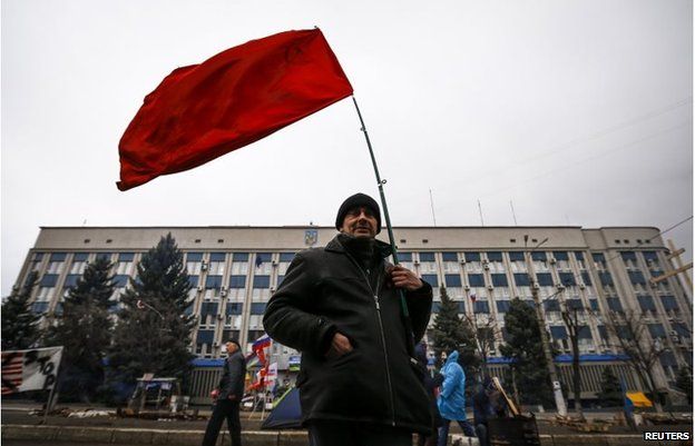 A pro-Russian supporter holds a Soviet flag in front of the seized office of the SBU state security service in Luhansk, in eastern Ukraine April 13