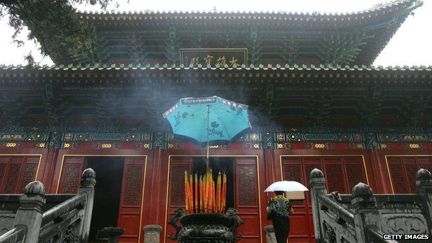 A woman enters a shrine at the Shaolin Temple in Henan Province, China