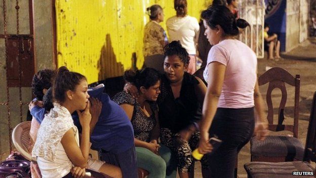 People gather in the streets outside their homes after an earthquake shook Managua on 13 April 2014