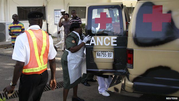 A military nurse helps victims of the blasts off an ambulance at the Asokoro General Hospital in Abuja (14 April 2014)