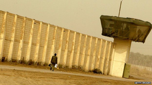 A man walks past Abu Ghraib prison (2009)