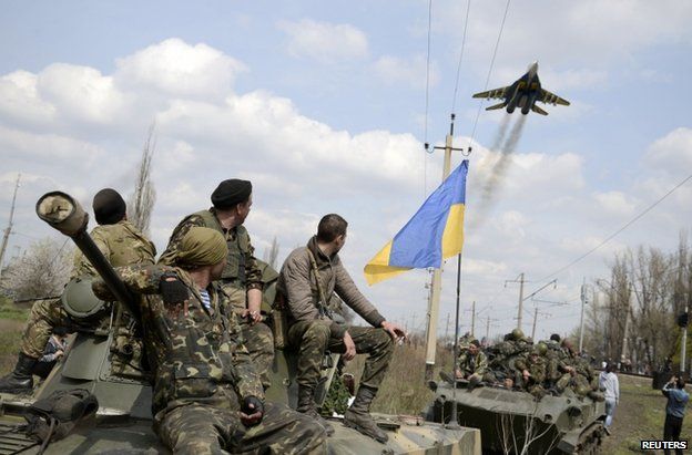 Ukrainian soldiers watch a jet pass near Kramatorsk, Ukraine, 16 April