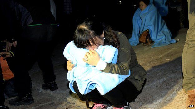 Relative cries as she waits for missing passengers at a port in Jindo, South Korea, on 16 April 2014