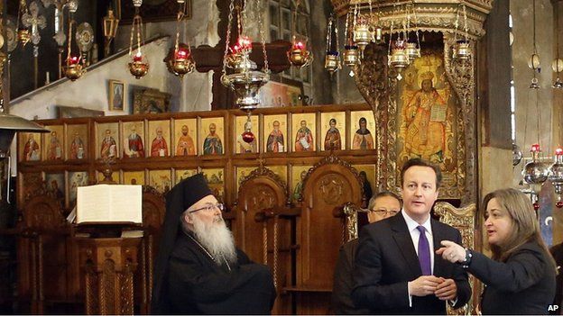 David Cameron talks to officials as he visits the Church of the Nativity in the West Bank town of Bethlehem on Thursday, March 13, 2014