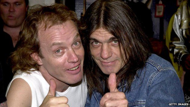 Band members Angus Young, left, and brother Malcolm Young of the Australian rock band AC-DC pose September 15, 2000